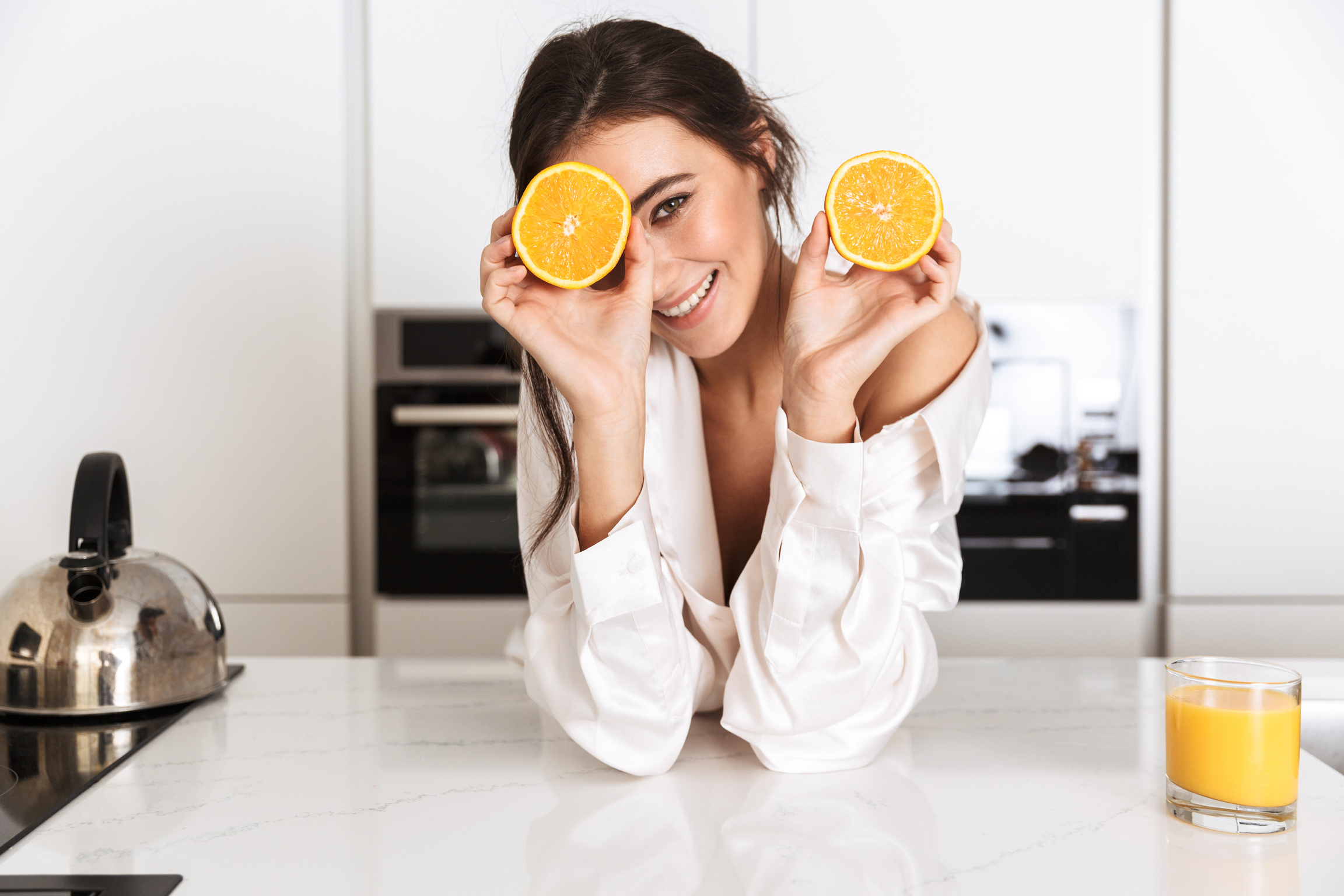 Woman Holding Slices of Orange Fruit